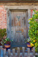 Fototapeta na wymiar brick bungalow with rustic wood Dutch door and picket fence