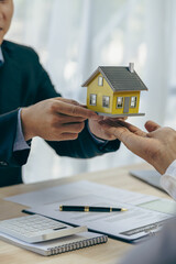 Real estate agents and insurance brokers, businessmen, professional consultants, ready to build a toy model house, choose a house-by-house model, house sale concept example.