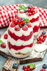 yogurt granola parfait with blueberry and raspberry on a light background. vertical image. top view. place for text