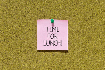 Time for lunch text on pink post-it paper pinned on bulletin cork board. This message can be used...