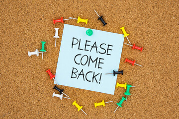Please come back text on light blue post-it paper pinned on bulletin cork board surrounding by multi color pins. This message can be used in business concept about coming back.