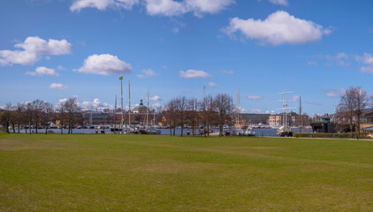 Panorama view over the island Djurgården, green field, boats and piers in the bay Ladugårdsviken, a sunny spring day in Stockholm