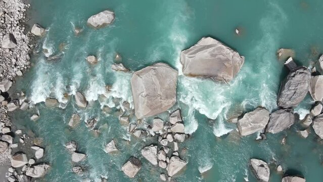 Drone descending over green and glacial water of Indus River, located in Gol valley of Skardu, Gilgit Baltistan, Pakistan. 
