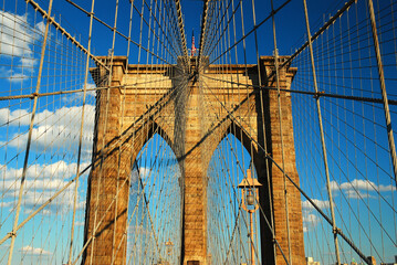 Long cables reach to and from the Gothic stone anchor of the historic Brooklyn Bridge in New York City
