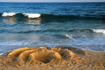 A circle design is placed un the sand of an ocean beach