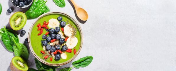 Fototapeta na wymiar Healthy Green Spinach Smoothie in a Bowl with Banana, Blueberry, Goji, and Chia Seed Toppings, Detox, Vegetarian Food
