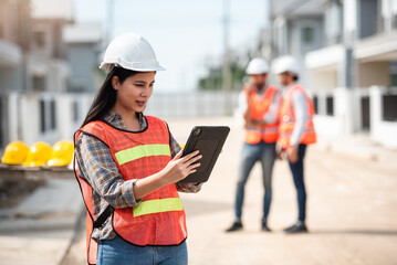 Construction worker, Engineering or architect woman using digital tablet for work at construction site , Engineer female inspection at real estate project.