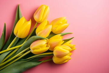 bouquet of yellow tulips on pink background top view
