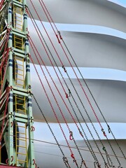 Abstract vertical (background) image of industrial ship with white metal windmill blades and multi-coloured cables - port of Rotterdam, the Netherlands, Europe