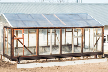 empty glass greenhouse in the village. Preparation of the harvest period in the spring