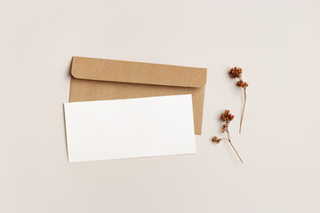 Empty white paper card and craft paper envelopment, autumn letter top view mock up, autumn greeting or invitation card with trend dry plant, minimal botanical style flat lay, fall season - obrazy, fototapety, plakaty