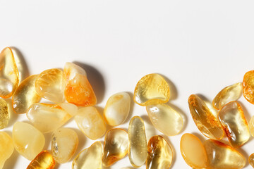 Natural gemstone amber texture background, light stones yellow ivory white colors with beautiful shadows and sunlight. Top view Amber texture. Aesthetic wallpaper, copy space, uncut stones.