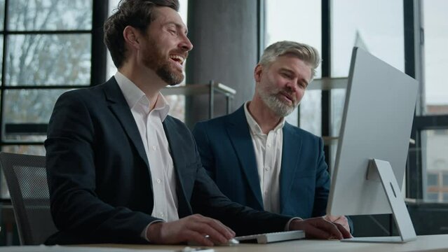 Caucasian mature business people looking computer screen work together partnership talking laughing men colleagues businessmen working on joint project using pc laugh having fun Generative AI