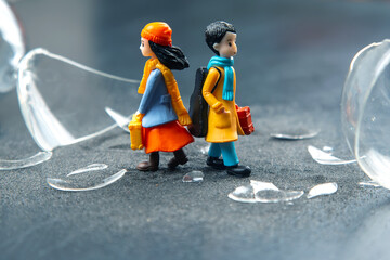 miniature people. a couple of people near a broken hourglass. crisis of personal relationships. concept of communication and dispute
