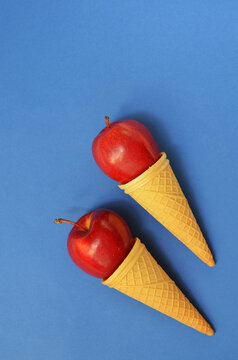 red apples in waffle cone on blue, colorful food background