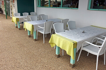 Tische und Stuehle an einem Restaurant