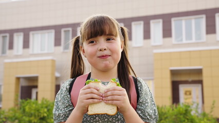 Feed child girl with sandwich, buy kid daughter one sandwich, feed child with sandwich, feed sandwiches children at school, buy sandwiches for all children at school and treat them all your friends.