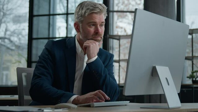 Mature focused thoughtful caucasian businessman marketing specialist working on computer in office man entrepreneur manager thinking analyzing finance digital data in Internet creating Generative AI