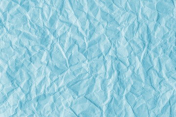 Recycled crumpled cyan paper texture background. Wrinkled and creased abstract backdrop, wallpaper with copy space, top view.