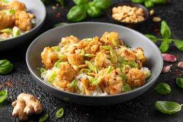 Fototapeta na wymiar Kung Pao Cauliflower with rice, peanuts and spices. Healthy vegan food.