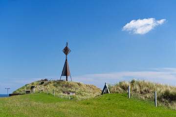 Aussichtsplattform Westkopf im Westen von Baltrum mit grüner Wiese und Zaun bei sonnigem Wetter