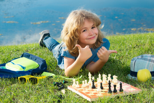 Little child play chess. Kid playing board game. Thinking child brainstorming and idea in chess game. Chess school and education concept.