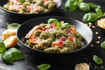 Italian potato gnocchi with green pesto sauce, bacon and parmesan cheese. Healthy food