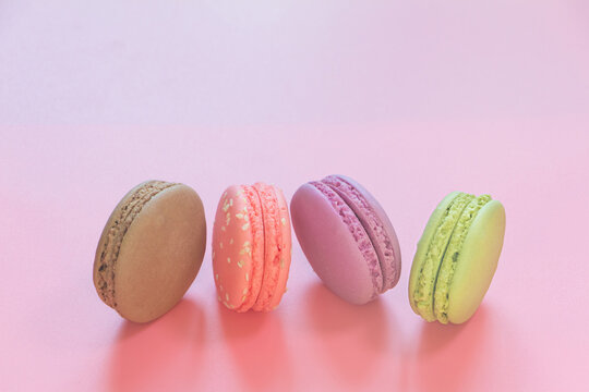 Multicolored Macarons cakes on pink background