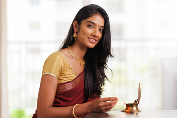 Beautiful Indian young women lightening deepa on Diwali day.