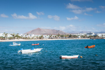 Fototapeta na wymiar Fishing boats in turquoise sea near Costa Teguise, Lanzarote, Canary Islands