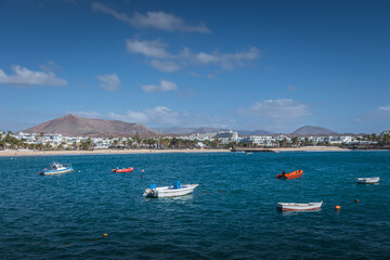 Fototapeta na wymiar Fishing boats in turquoise sea near Costa Teguise, Lanzarote, Canary Islands