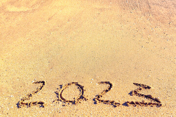 Year inscription on the sand . Written 2023 on the beach 