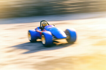 Bright blue gokart zooming around the track with its white wheel clearly visible. Speed drive concept. AI generation. Generative AI - obrazy, fototapety, plakaty