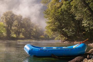 Fototapeta premium Preparando la balsa de rafting a la mañana para su navegación en un entorno de naturaleza pura. Rio Manso, Bariloche, Argentina. 