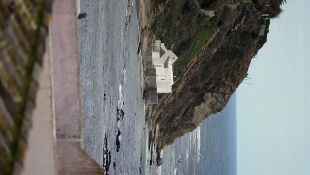Seascape of Tarifa coast with mountain rock, sea and houses in summer clear day. Generative AI