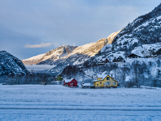 Traditional norwegen wooden huses after winter nnow in Eidfjord village during sunset, Norway