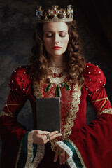 medieval queen in red dress with book and crown