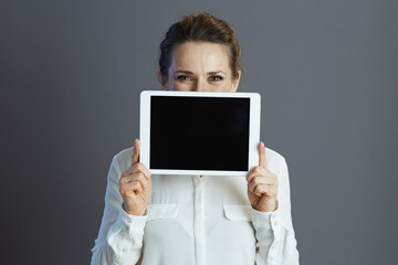 trendy woman worker showing tablet PC isolated on gray