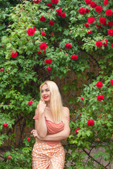 Beautiful woman with long blonde hair and red lips wearing pink clothes