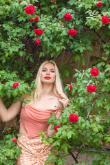 Beautiful woman with long blonde hair and red lips wearing pink clothes
