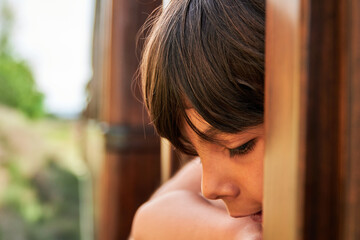 close up of a boy leaning out the window of a vintage train during a ride