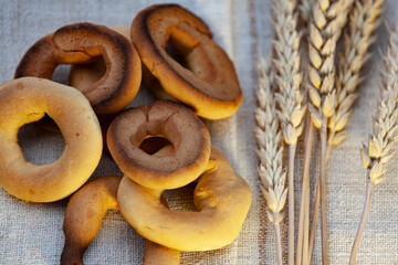 Homemade baking. Dry bagels on a napkin against the background of spikelets of wheat