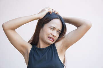 Asian woman having itchy head from dandruff.