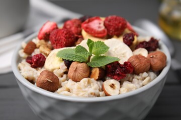 Oatmeal with freeze dried fruits, nuts and mint in bowl, closeup