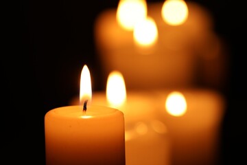 Burning candles on black background, closeup. Space for text