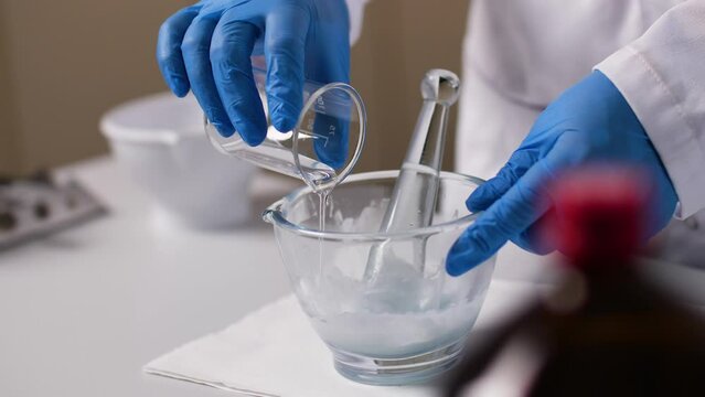 A liquid is placed in a glass bowl. A medical cream is stirred in the process.