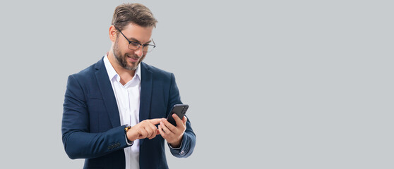 Man in suit using smart phone. Portrait attractive cheerful guy using phone, calling on mobile phone. Handsome man with smart phoneon studio isolated background. Banner, copy space. - obrazy, fototapety, plakaty