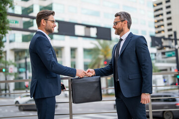 Business deal. Two business man hold business briefcase. Business contract transfer deal. Handover of a suitcase in hands of partners. Illegal deal handover. Hands give briefcase for exchange.