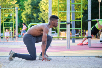 Young fit shirtless black man ready to run outdoors on sunny summer day. Fitness and sport lifestyle.