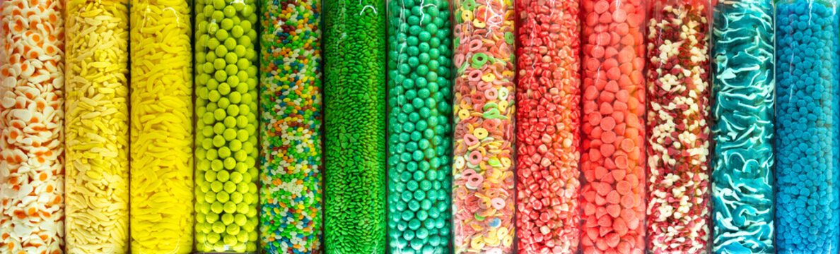 Transparent plastic tubes full of colorful candies. Rainbow jelly